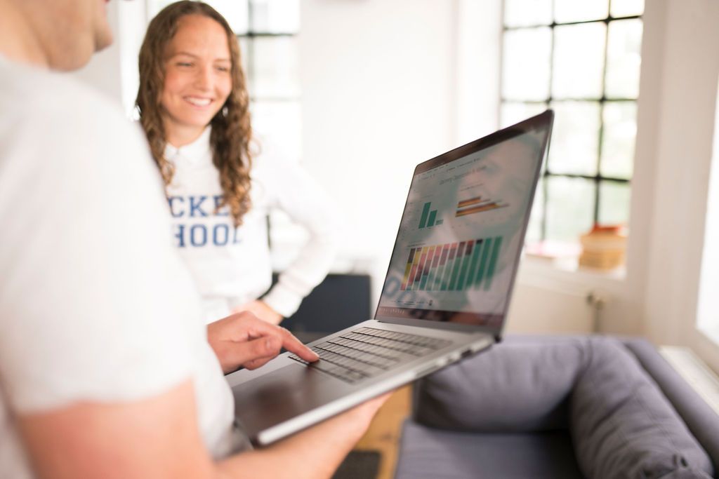 Two people looking together at a laptop showing a chart